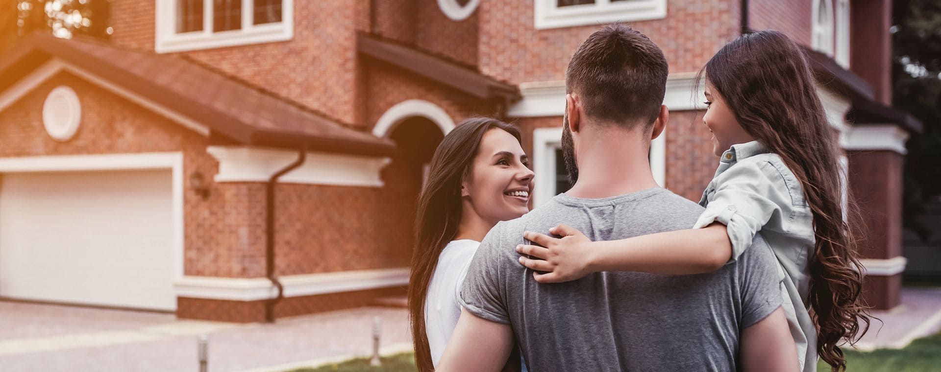 Eine glückliche Familie steht vor einem Haus