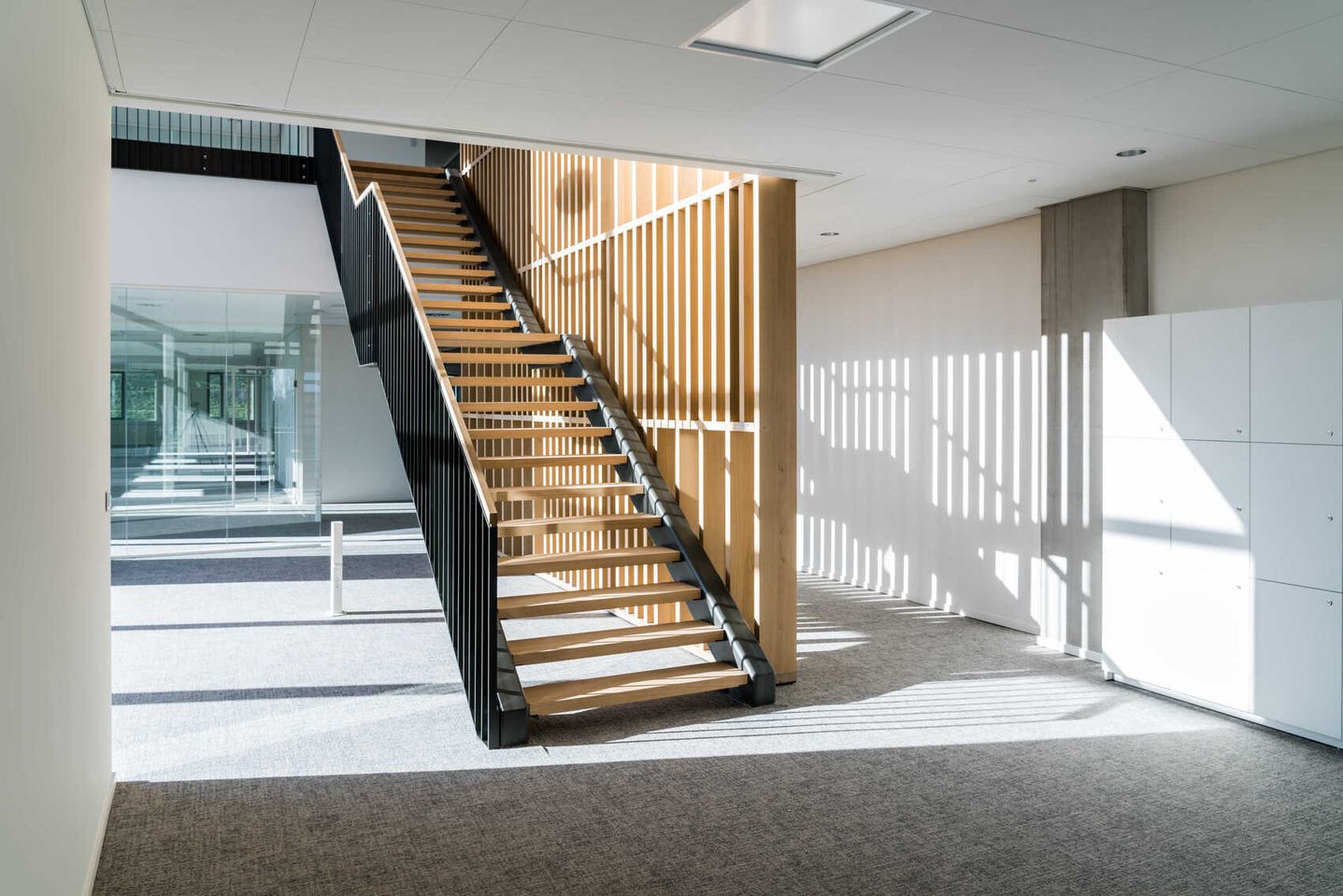 Treppe in einem Bürogebäude mit Holzlatten, die eine moderne und einladende Atmosphäre schaffen